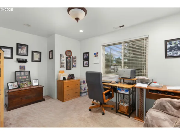 a view of a workspace with furniture and a window