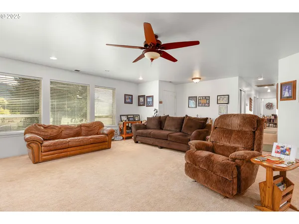 a living room with furniture ceiling fan and a window