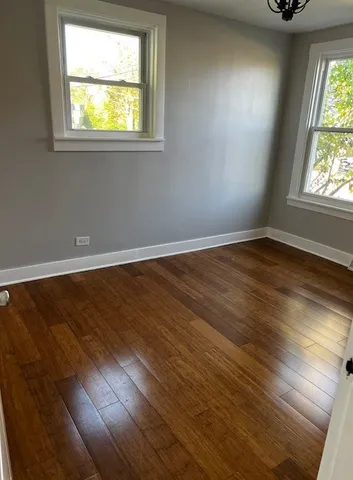 an empty room with wooden floor and entrance