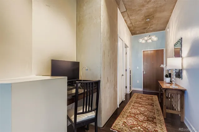 a view of a hallway with workspace and wooden floor