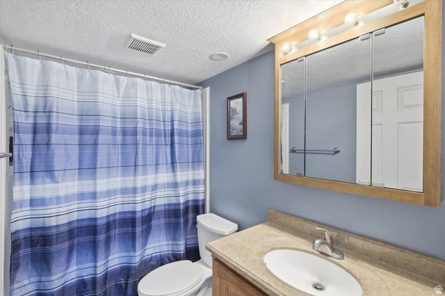 1095 Park Avenue Logan, UT 84321 - Photo 17 of 27 Full bath with vanity, a textured ceiling, and a shower with curtain