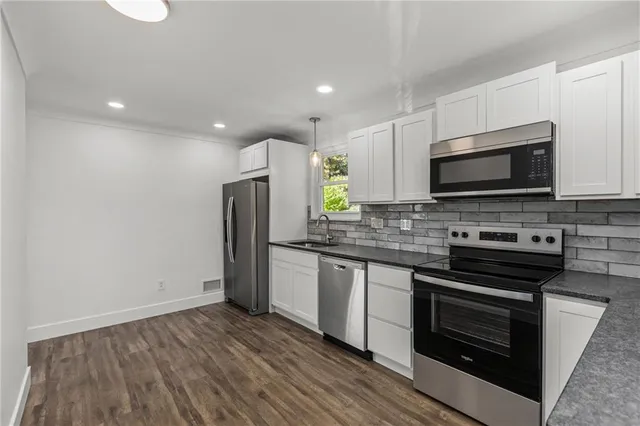a kitchen with stainless steel appliances a stove a microwave and sink