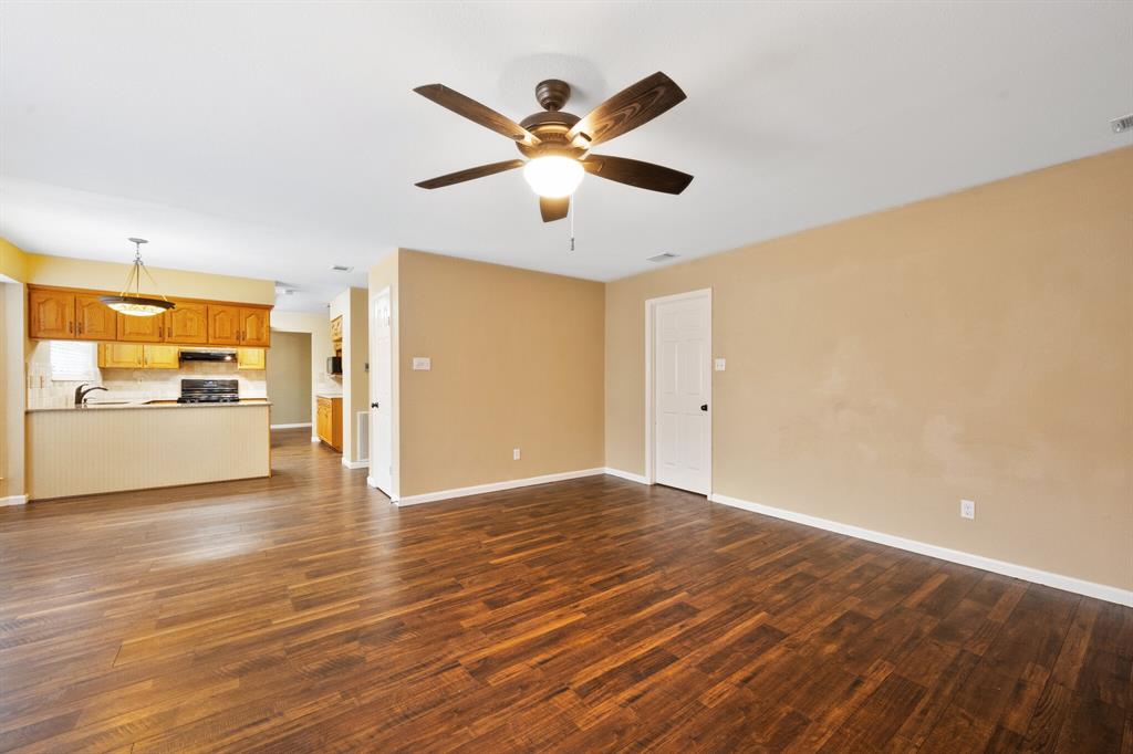 7517 Point Reyes Drive Fort Worth, TX 76137 - Photo 10 of 30 Spacious living area featuring wood-finish flooring, a ceiling fan with integrated lighting, and neutral wall tones