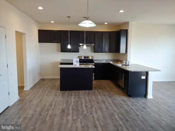 a kitchen with kitchen island granite countertop a sink cabinets and wooden floor