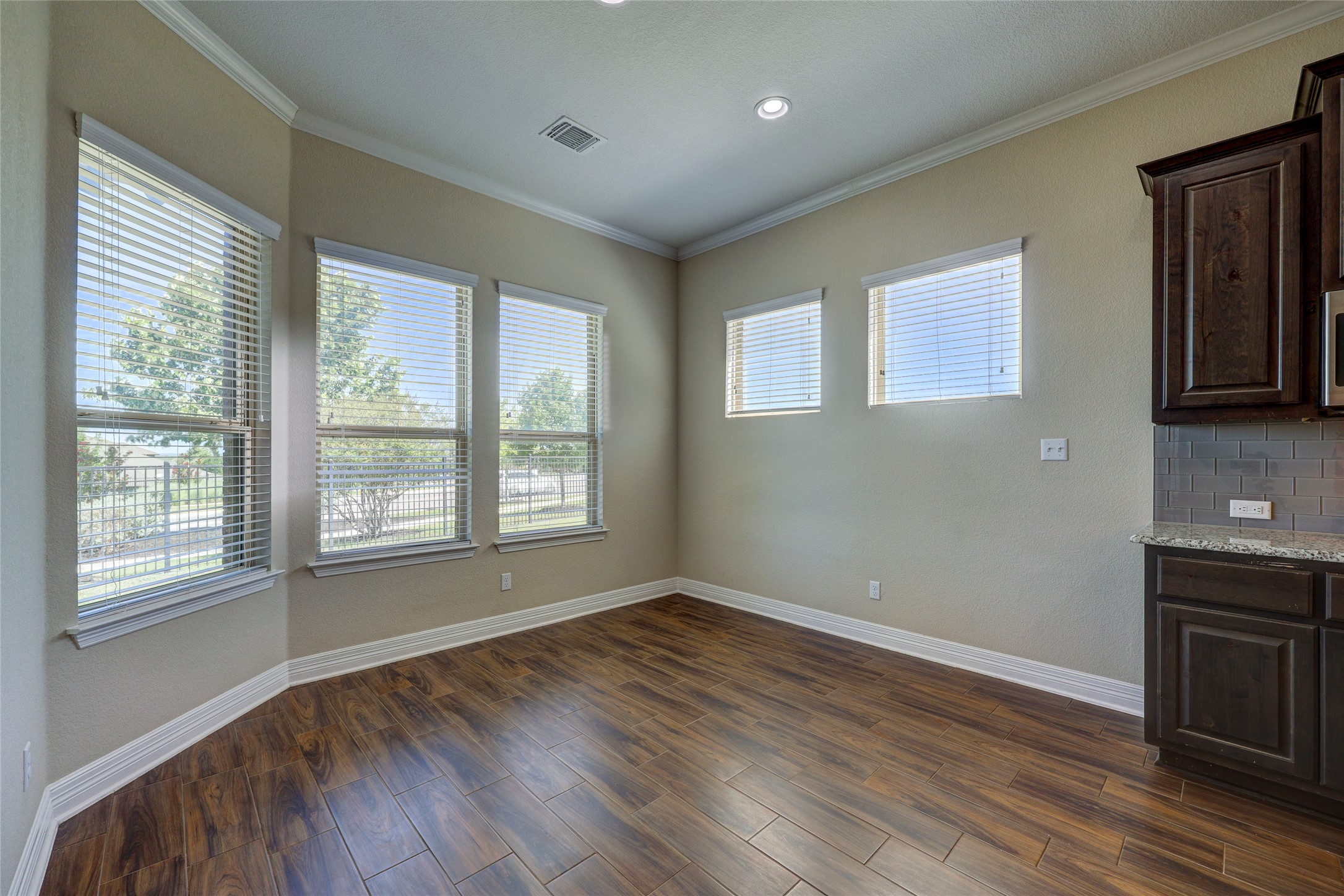 409 Betony Loop Buda, TX 78610 - Photo 6 of 38 Naturally illuminated dining area features crown molding, recessed lighting, and rich wood flooring.