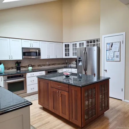 a kitchen with stainless steel appliances granite countertop a stove a sink and a refrigerator
