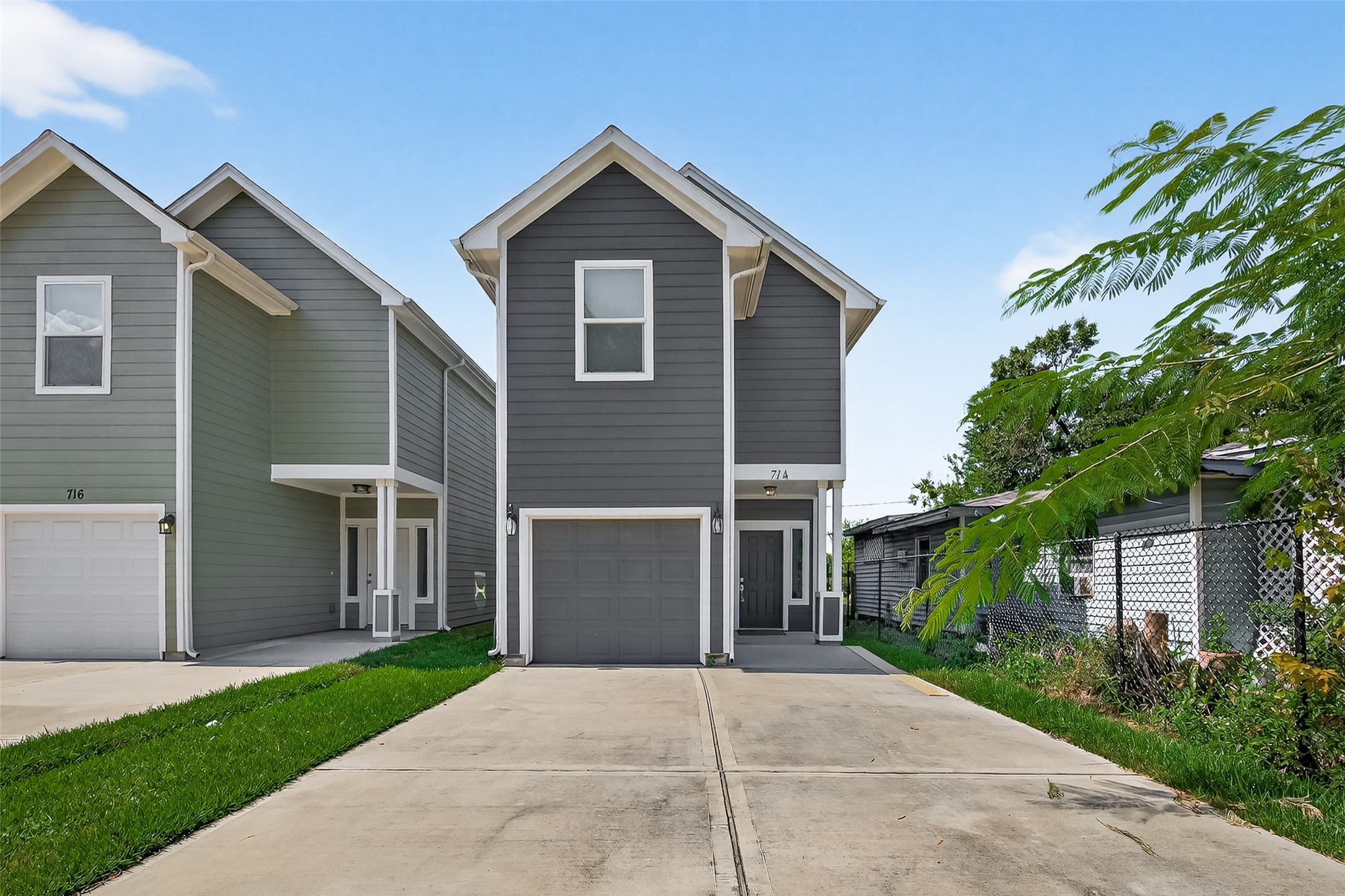 a front view of a house with a garden and trees
