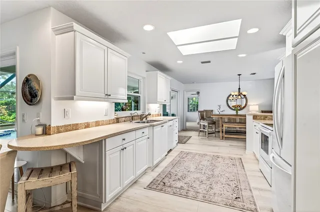 a kitchen with stainless steel appliances kitchen island granite countertop a table and chairs in it