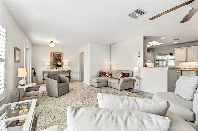 a living room with furniture and view of kitchen