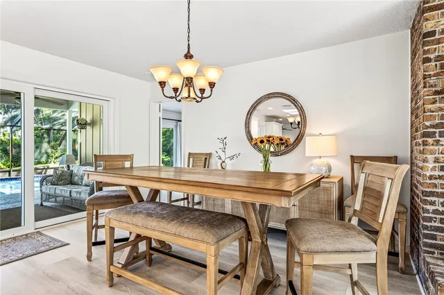 a view of a dining room with furniture a chandelier and wooden floor