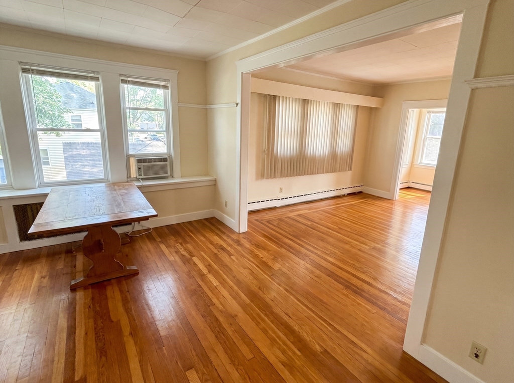 175 Coleman Street, Unit 2 Malden, MA 02148 - Photo 3 of 7 an empty room with wooden floor and windows