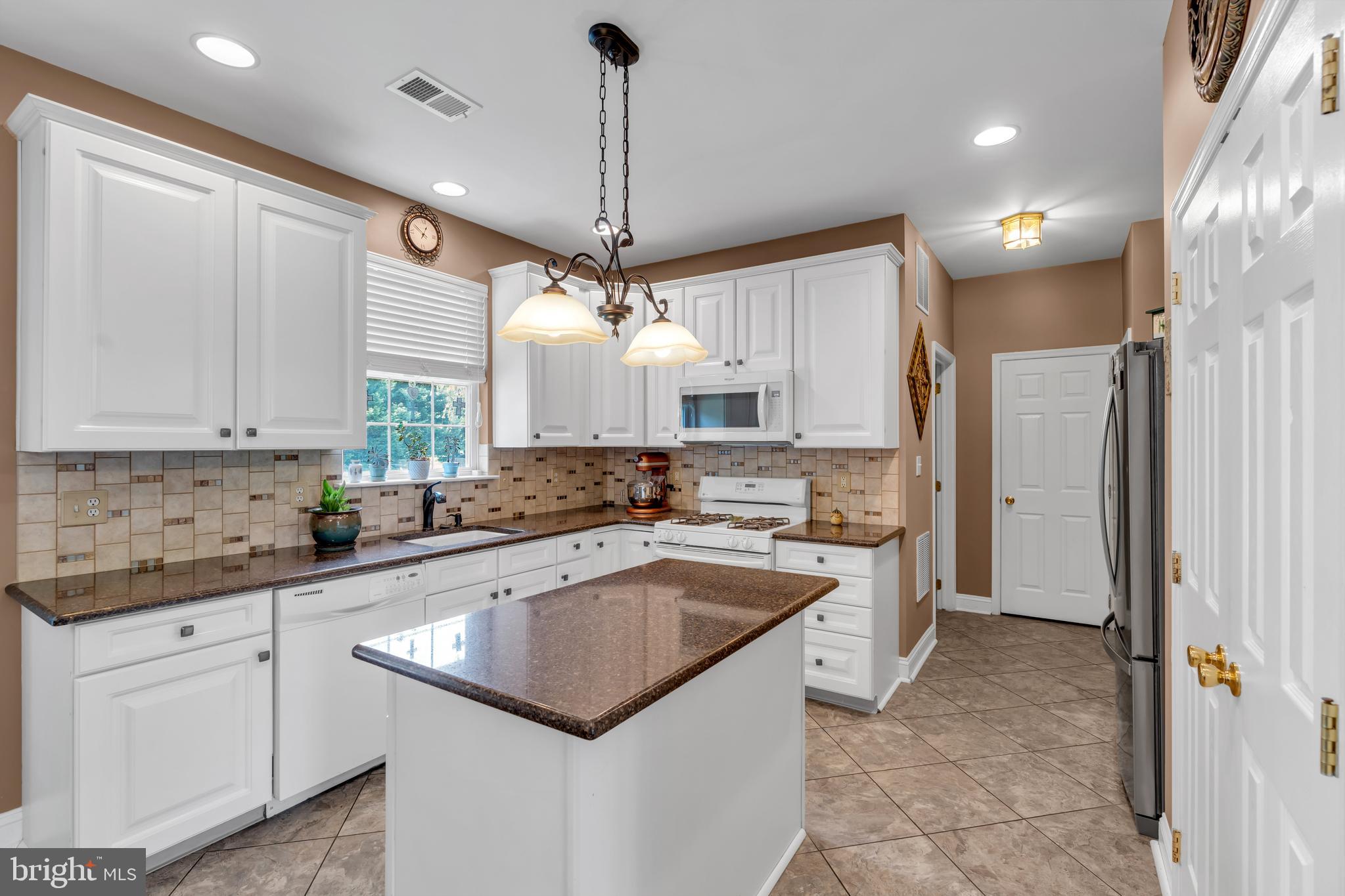 3 Pheasant Court, Unit 2710 Columbus, NJ 08022 - Photo 9 of 39 a kitchen with a white center island a sink stainless steel appliances and cabinets