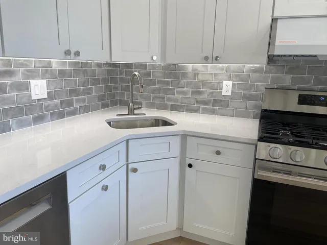 a kitchen with white cabinets and a stove