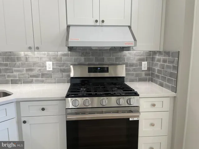 a stove top oven sitting inside of a kitchen