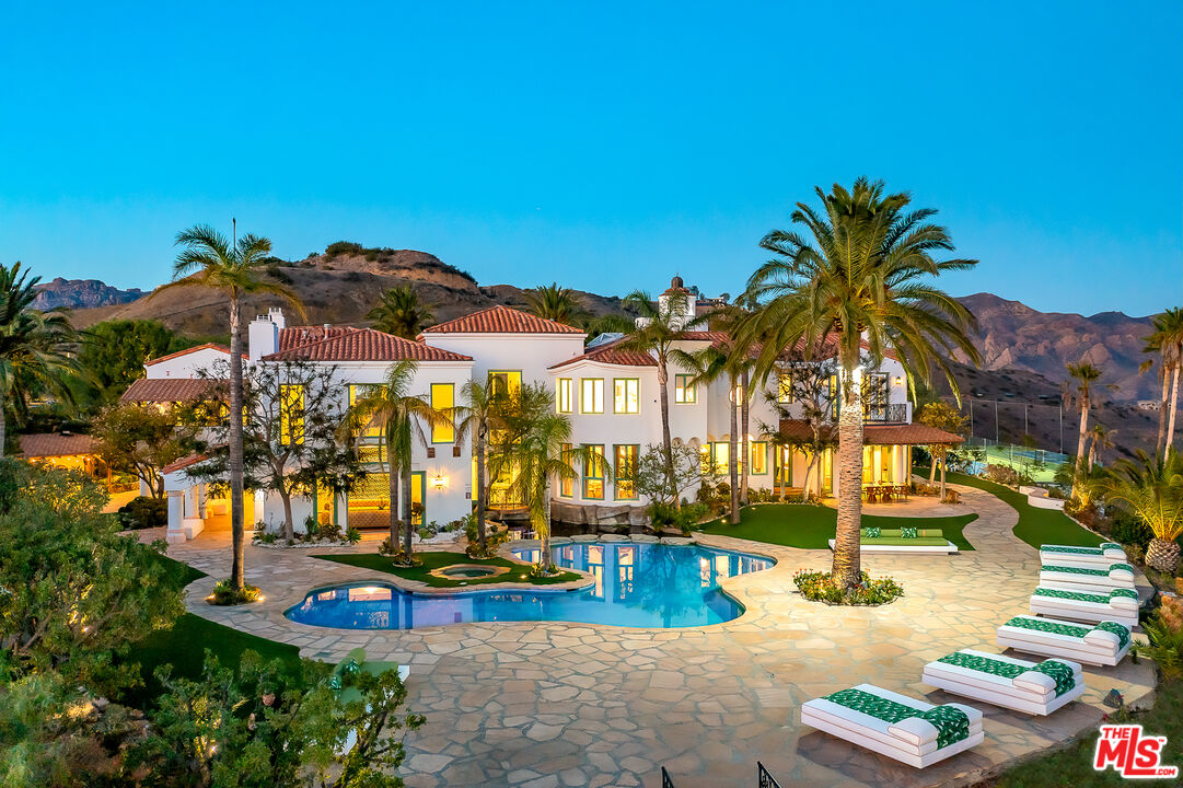 10502 Yellow Hill Road Malibu, CA 90265 - Photo 6 of 22 a view of a swimming pool with a lawn chairs under an umbrella