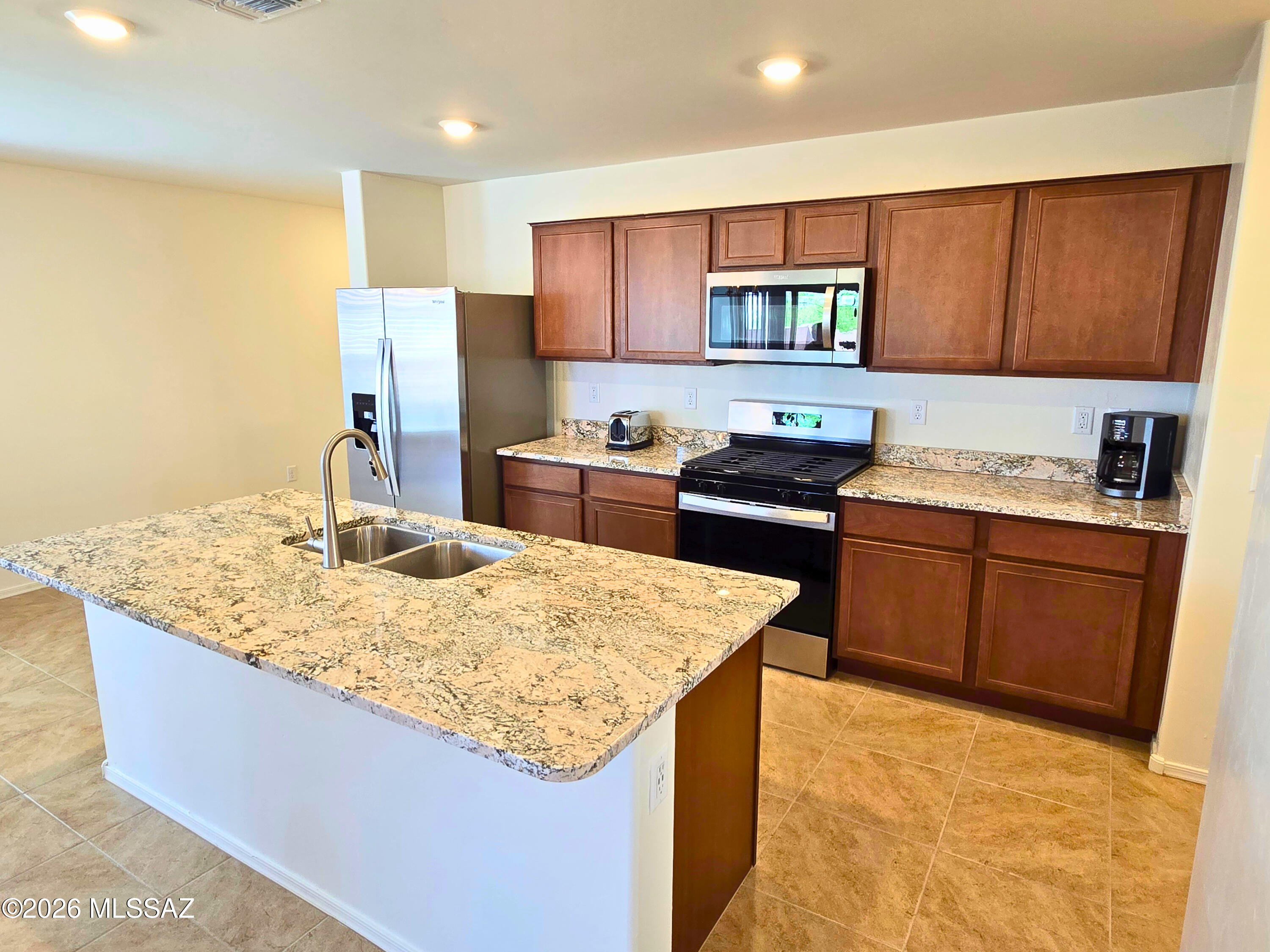 6343 South Rigby Way Tucson, AZ 85746 - Photo 5 of 29 a kitchen with stainless steel appliances granite countertop a sink stove and refrigerator