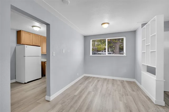 an empty room with wooden floor and a window