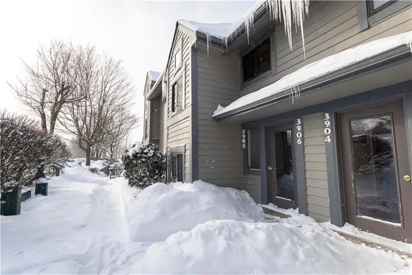 a view of a house with a yard covered in snow