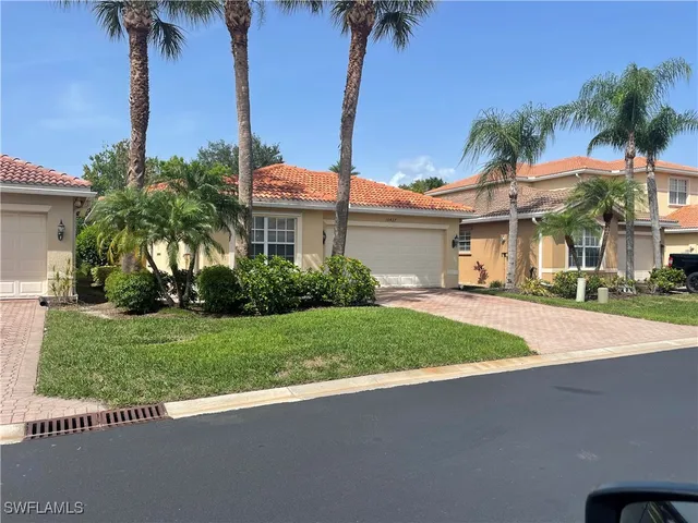 a front view of a house with a garden and tree