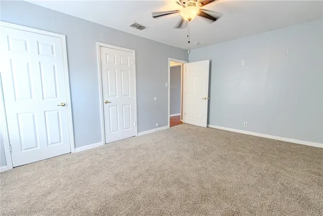 an empty room with a chandelier fan