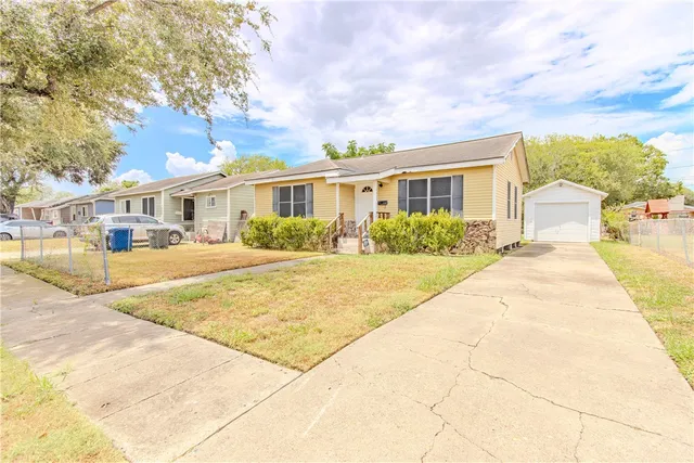 a front view of house with yard and trees around