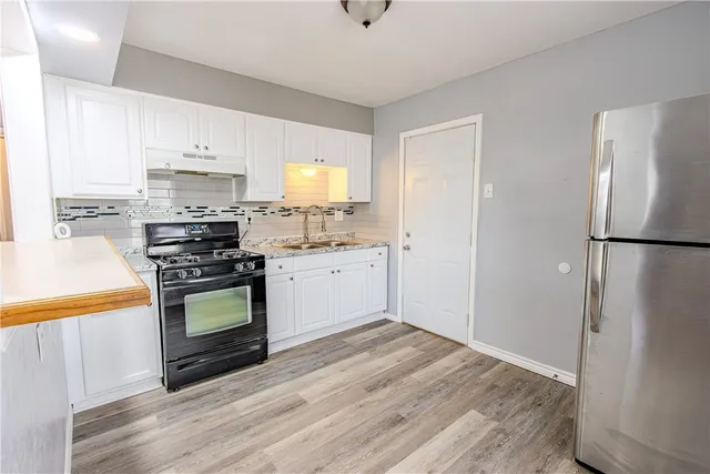 a kitchen with stainless steel appliances a stove a sink and a refrigerator