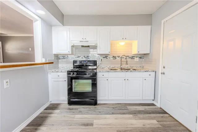 a kitchen with a sink stove and cabinets