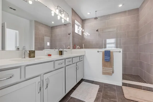 a spacious bathroom with double sink and a large mirror