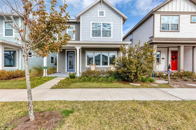 a front view of a house with a yard and potted plants