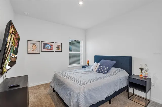 a bedroom with a bed and a lamp on dresser