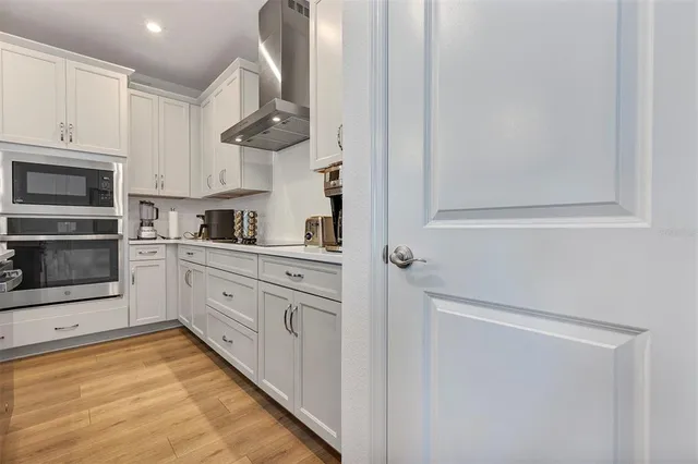 a kitchen with white cabinets and stainless steel appliances