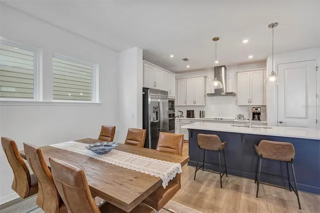 a kitchen with a dining table chairs and refrigerator