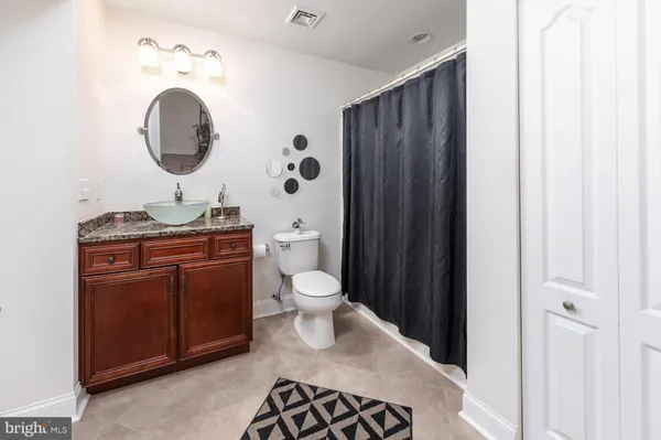 a bathroom with a toilet sink vanity and mirror