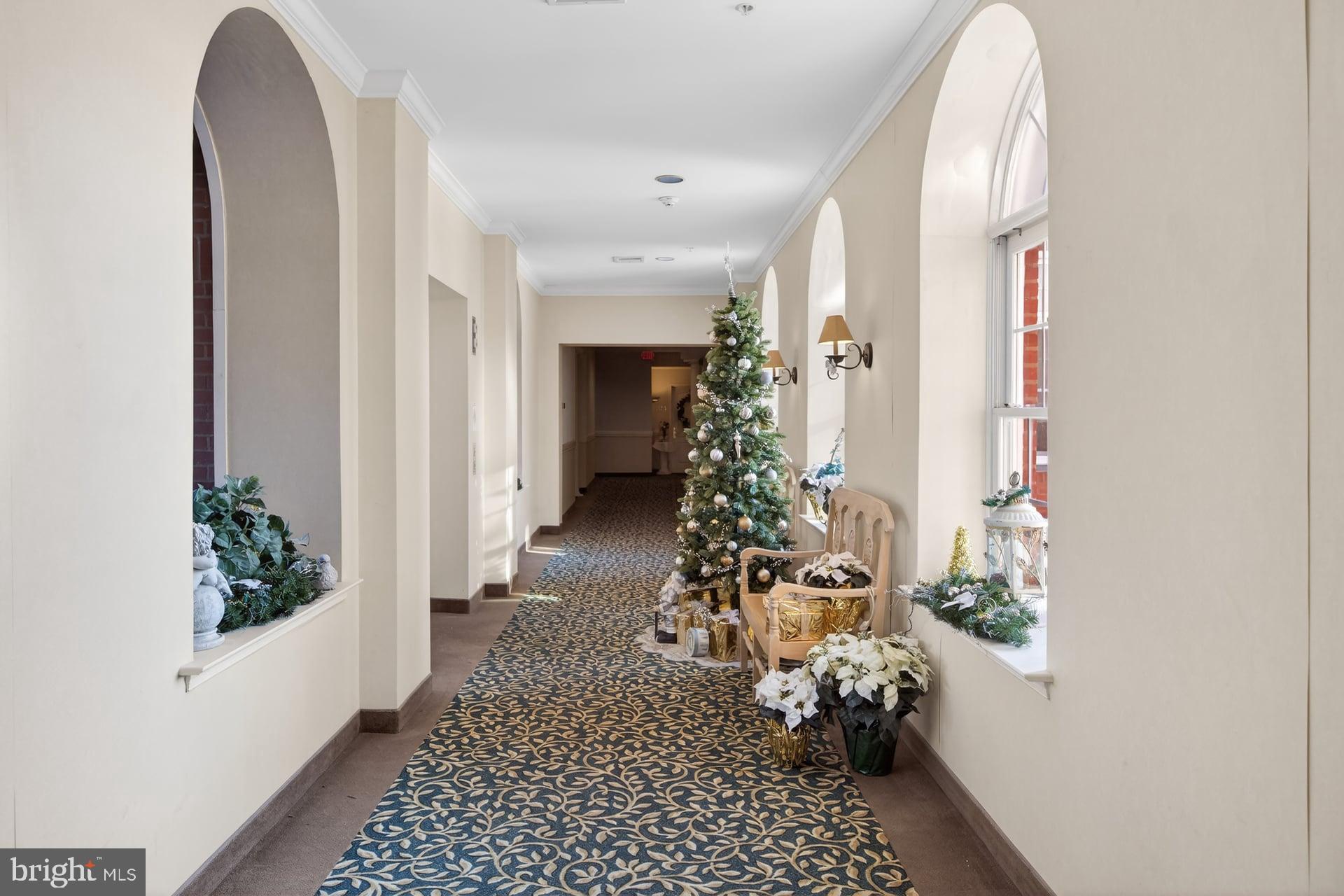 100 Aura Road, Unit 206 Clayton, NJ 08312 - Photo 14 of 25 a view of a hallway with wooden floor and a chandelier