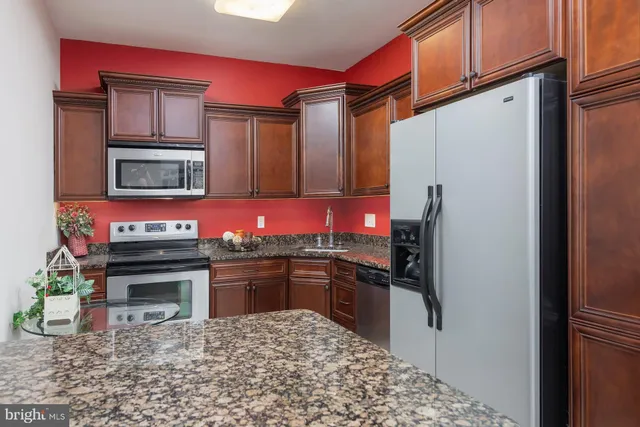 a kitchen with granite countertop a refrigerator stove and microwave