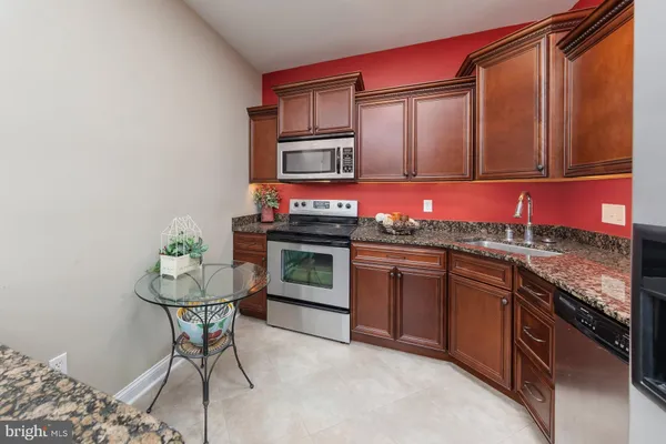 a kitchen with stainless steel appliances granite countertop a sink stove and cabinets