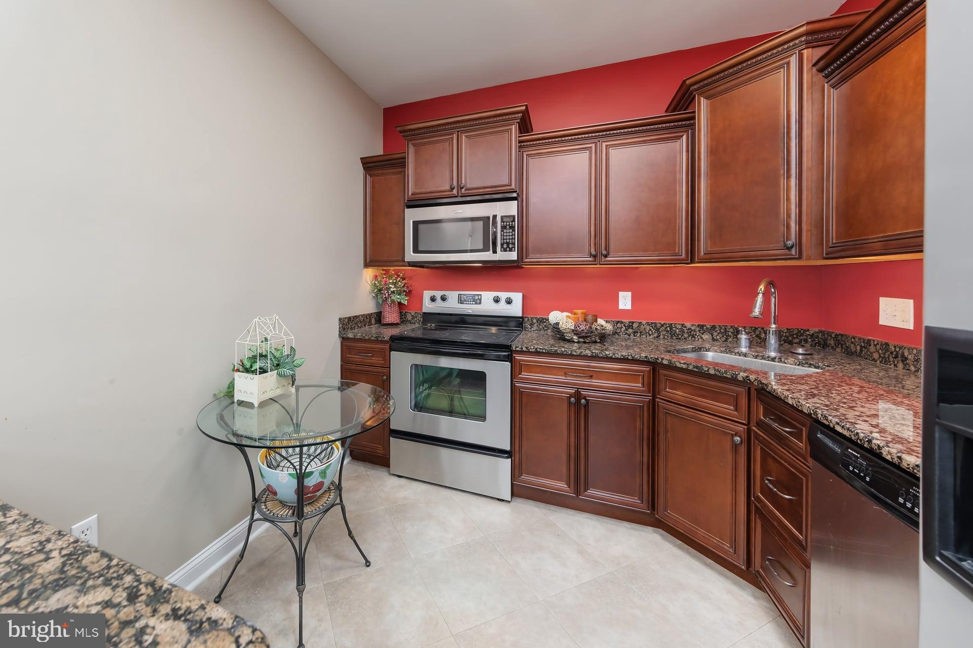 100 Aura Road, Unit 206 Clayton, NJ 08312 - Photo 9 of 25 a kitchen with stainless steel appliances granite countertop a sink stove and cabinets