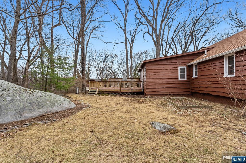 6 Partridge Trail Butler, NJ 07405 - Photo 33 of 37 a backyard of a house with large trees and wooden fence