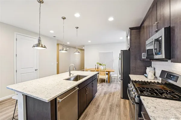 a kitchen with stainless steel appliances granite countertop a sink stove and refrigerator