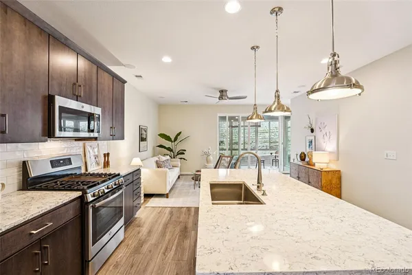 a large kitchen with kitchen island a stove a sink a counter space and wooden floor