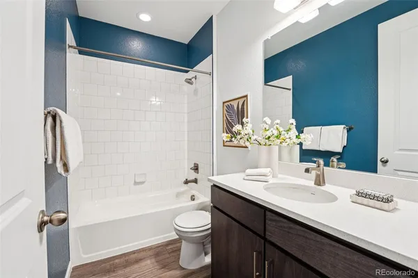 a bathroom with a sink a toilet a mirror and shower