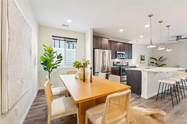 a dining room filled chandelier and kitchen view