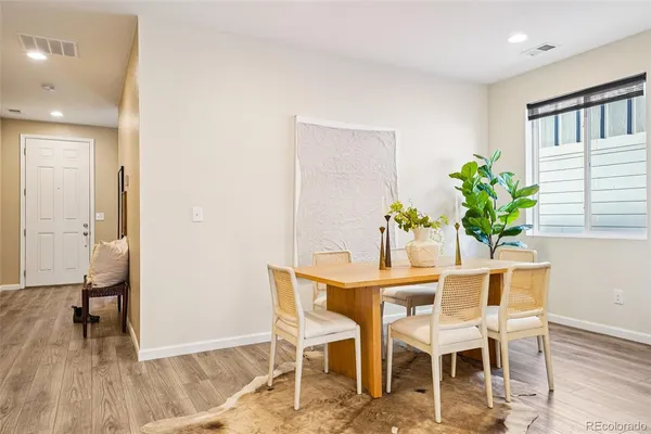 a dining room with furniture and a potted plant