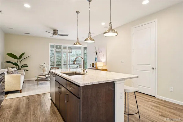 a kitchen with a sink a island a stove and a wooden floor