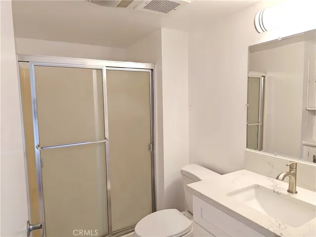 a bathroom with a granite countertop sink toilet and shower