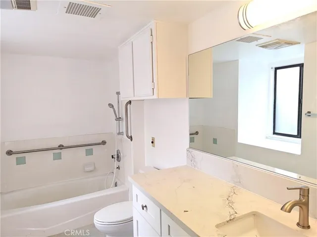 a bathroom with a granite countertop sink a toilet and bathtub