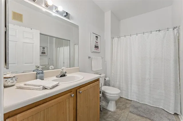 a bathroom with a double vanity sink toilet and shower