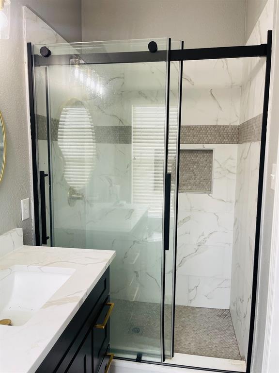 516 Angela Lane Euless, TX 76039 - Photo 25 of 39 Full bathroom featuring a textured wall, a marble finish shower, and vanity
