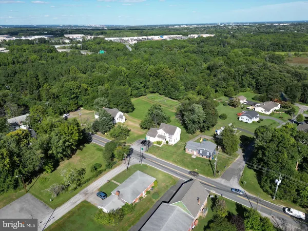 an aerial view of residential houses with outdoor space and trees