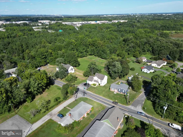 an aerial view of residential houses with outdoor space and trees